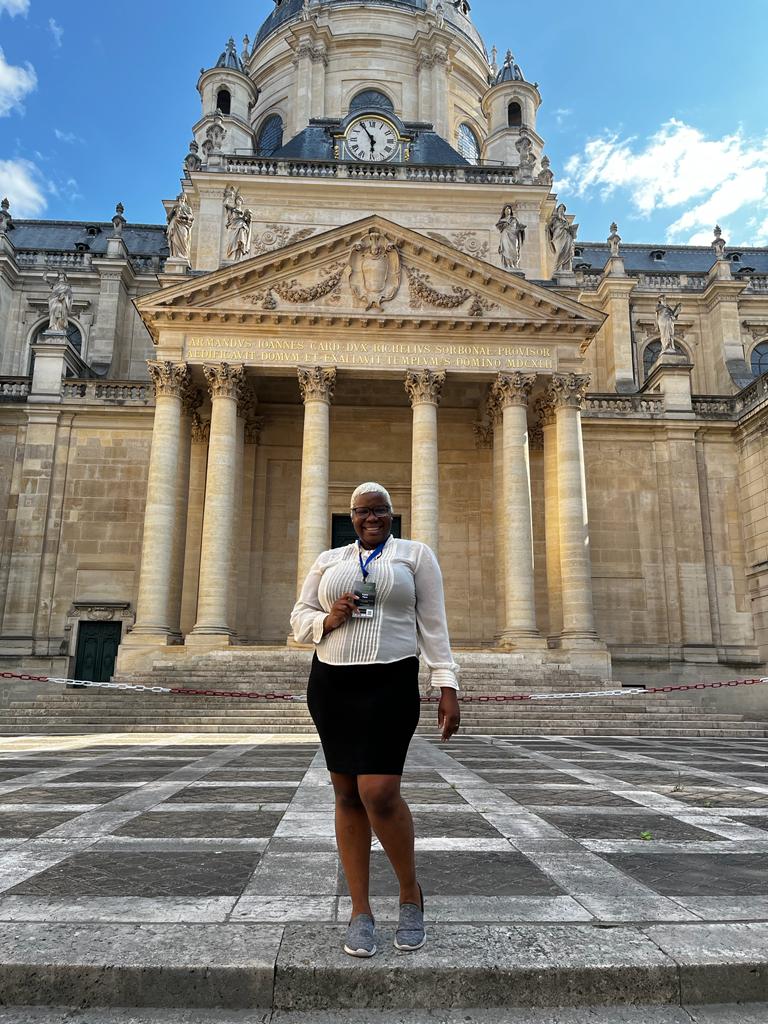 Crystal Payne standing in front of a Sorbonne Université building with Certificate.