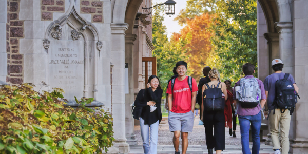 Students walking through an archway on the campus of Washington University in St. Louis