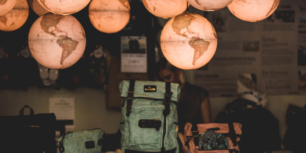 Backpacks stacked underneath several hanging globes