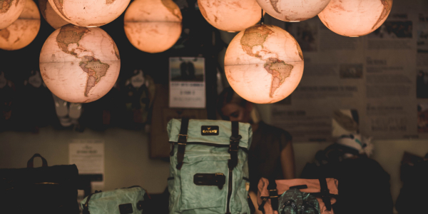 Backpacks stacked underneath several hanging globes