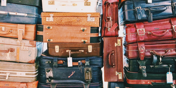 Different colors and sizes of suitcases stacked on top of each other