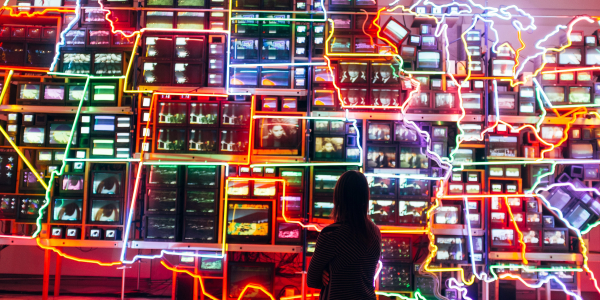 Person looking at a wall map of the USA, states are outlined in neon lights