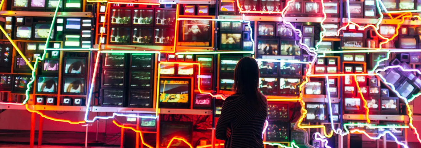 Person looking at a wall map of the USA, states are outlined in neon lights
