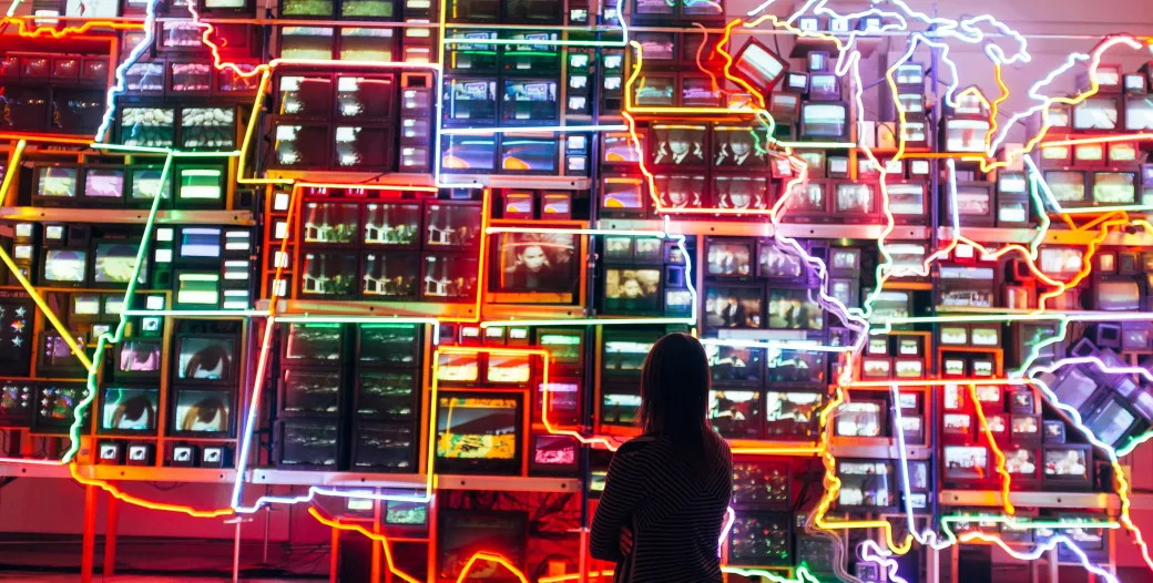 Person looking at a wall map of the USA, states are outlined in neon lights