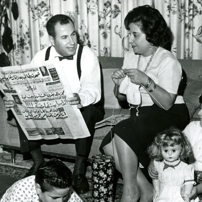 Arab Family in Living Room Reading Arabic Newspaper