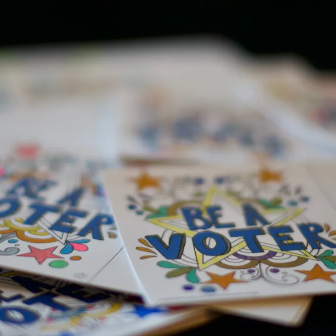 Colorful stickers with hand drawn flowers and blue text, BE A VOTER